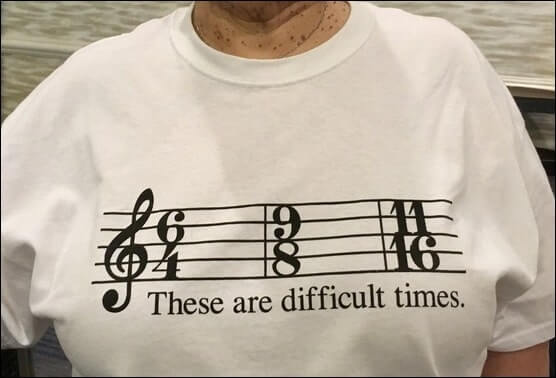 T-shirt with musical staff and unusual time signatures, with caption" "These Are Difficult Times"